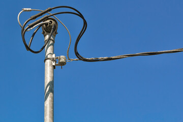 An electrical power service mast or riser and blue sky