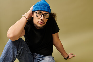 Charming young man with beard and blue beanie poses casually in a stylish setting