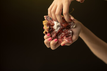 In this vivid image, hands exhibit a broken cherry pie slice, emphasizing the sensory appeal and...