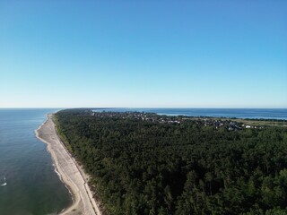 Spectacular aerial perspective of Baltic coastal settlement surrounded by lush green forest