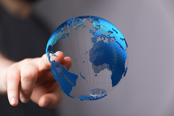 Person interacts with a digital globe, representing global network, connection, and technology.