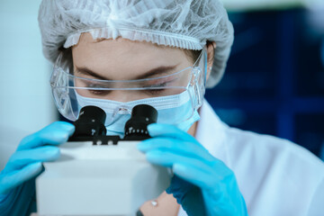Scientist analyzes biological samples using advanced laboratory equipment for medical research,...