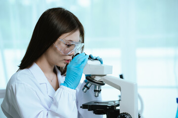 Scientist analyzes biological samples using advanced laboratory equipment for medical research,...