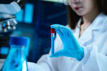 A female scientist conducts research in a modern laboratory, wearing protective gear, analyzing...