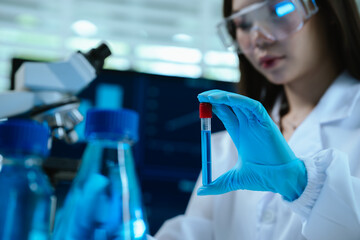 A female scientist conducts research in a modern laboratory, wearing protective gear, analyzing...