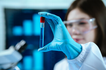 A female scientist conducts research in a modern laboratory, wearing protective gear, analyzing...