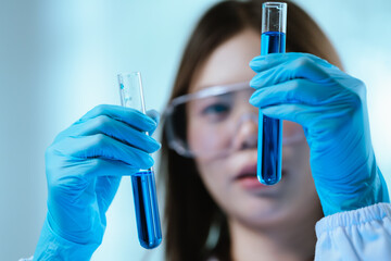 A female scientist conducts research in a modern laboratory, wearing protective gear, analyzing...