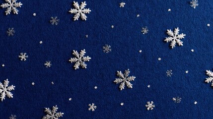 A background of deep blue paper with a scattering of silver foil snowflakes, elegant and simple winter theme. 