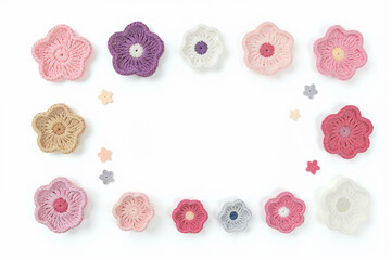 Flat lay of various crochet flowers in different shapes and pastel colors, arranged on a white background with copy space inside