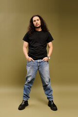 Handsome young bearded man standing confidently in casual attire against a textured backdrop