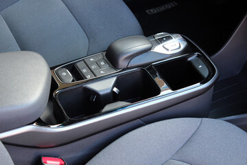 Close up electric car automatic transmission. Central console in interior of electric car. Gear shift in new electric car. Selector automatic transmission with leather in interior of new modern car.