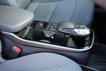 Close up electric car automatic transmission. Central console in interior of electric car. Gear shift in new electric car. Selector automatic transmission with leather in interior of new modern car.