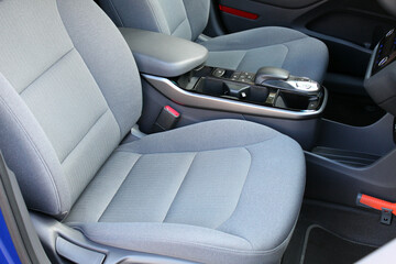 New electric car armrest. Close up Lux electric car automatic transmission. Electric Car inside, driver and passenger seats, cup holders and armrest. Premium Electric Car interior.