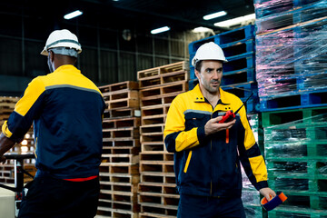 African male warehouse employee wearing safety uniform transporting cardboard boxes using manual...