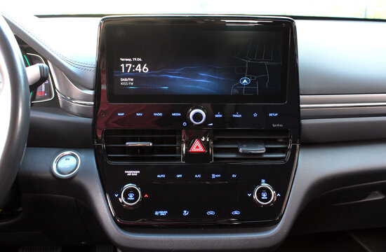 Screen multimedia system on dashboard in a modern electric car. Panel of a premium electric car. Close-up of an electronic dashboard in a modern car.