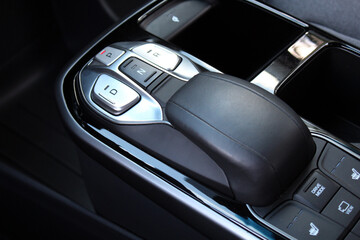 Close up electric car automatic transmission. Gear shift in new electric car. Selector automatic transmission with leather in the interior of a new modern car. Car Black leather interior.