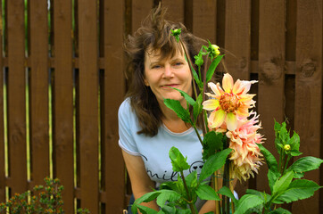 Lady posing beside a Penhill Watermelon Dahlia.