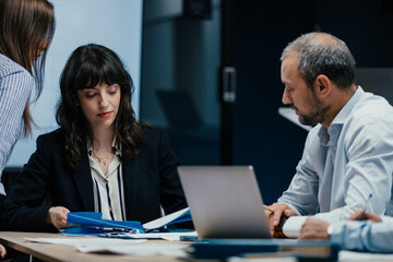 Executive business meeting with performance review on TV screen in luxury office boardroom
