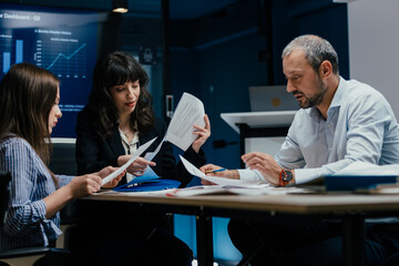 Executive business meeting with performance review on TV screen in luxury office boardroom