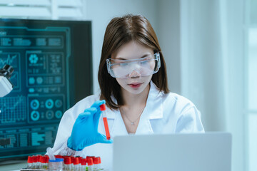 A scientist in a laboratory conducts a medical experiment with a red liquid in a test tube,...