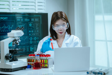 A scientist in a laboratory conducts a medical experiment with a red liquid in a test tube,...