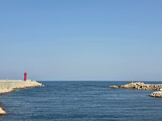 Fototapeta premium Blue sky and blue sea meet horizon, clear and clean seascape, beautiful coastal natural landscape background, Yeongdeok, South Korea - 푸른 하늘과 푸른 바다가 맞닿은 수평선, 맑고 깨끗한 바다 풍경, 아름다운 해안가 자연 경관 배경, 영덕, 한국