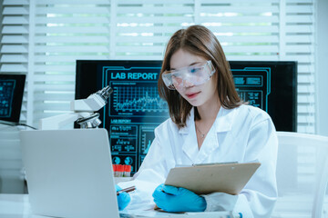 A scientist in a laboratory conducts a medical experiment with a red liquid in a test tube,...