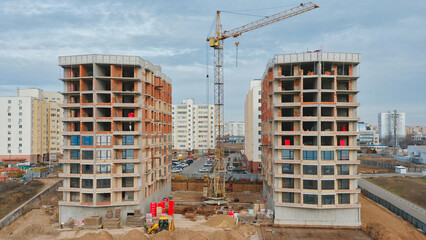 Construction progress of residential buildings with crane and equipment in urban area