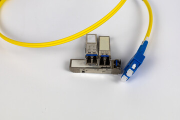 Yellow coiled fiber optic patch cord with blue connectors SFP modules are essential for high-speed...
