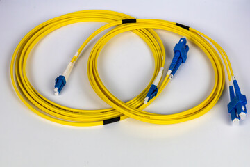 Bright yellow fiber optic patch cords, neatly wrapped, are displayed on a clean white background.