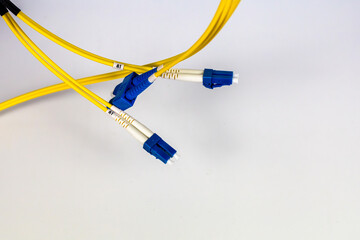 Bright yellow fiber optic patch cords, neatly wrapped, are displayed on a clean white background.