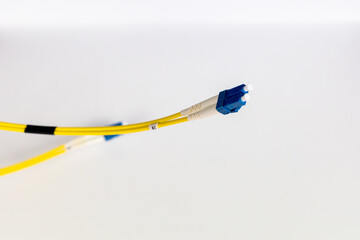 Bright yellow fiber optic patch cords, neatly wrapped, are displayed on a clean white background.