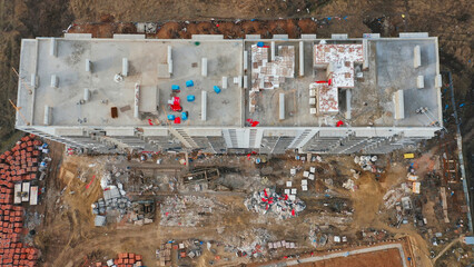 Construction progresses on a multi-story residential building in a bustling development area