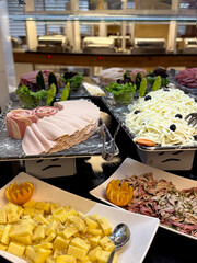 buffet table offering cheese, deli meats, and light snacks at all-inclusive restaurant. Concept of...