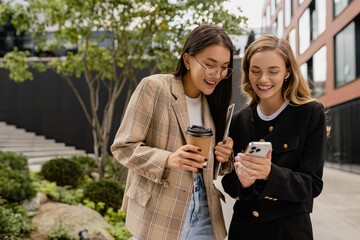 young pretty women walking talking in street doing business