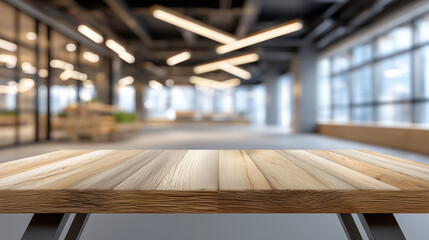 A clean wooden table surface in a modern office with blurred bright lights and glass walls in the background