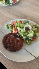 Tasty sausage with fresh salat on a plate