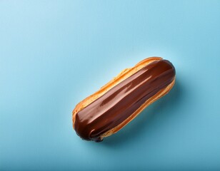 eclair au chocolat a la creme patissiere sur fond bleu pastel avec grand espace negatif pour communication ou publicite culinaire