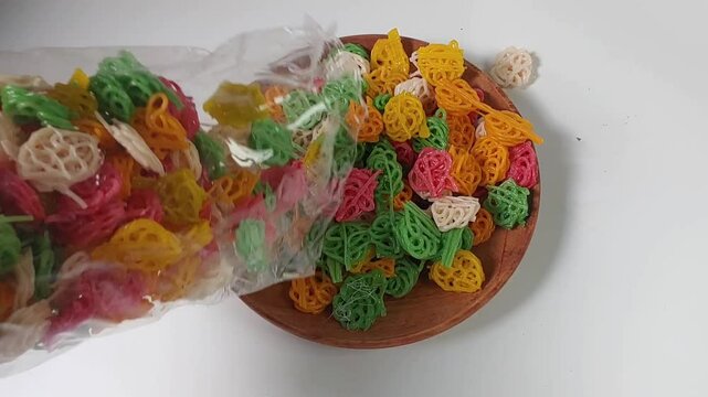 Kerupuk bunga or kerupuk rose or flower cracker or rose cracker falls from plastic pack to the plate, are typically deep-fried until crispy and are often served as a snack or a side dish in Indonesia.