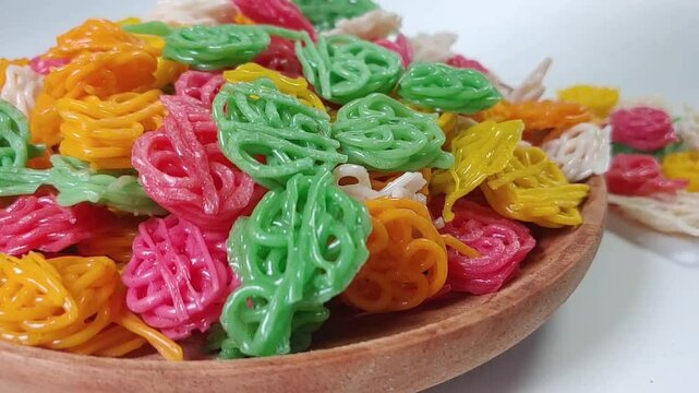 Kerupuk bunga or kerupuk rose or flower cracker or rose cracker falls on a wooden plate, are typically deep-fried until crispy and are often served as a snack or a side dish in Indonesia.