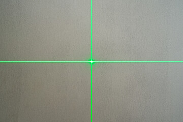 The green laser line from the leveling device shows the crossing of vertical and horizontal lines...