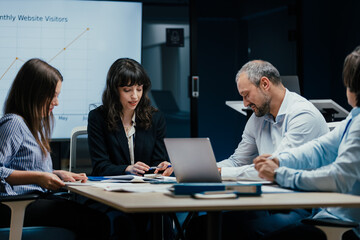Business executives and assistants brainstorming investment risk evaluation in corporate boardroom