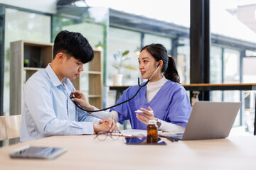 Asian woman nurse use stethoscope, checking up heart beat, lunch of auscultation in doctor office...
