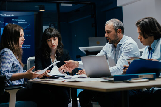 Business executives and assistants brainstorming investment risk evaluation in corporate boardroom