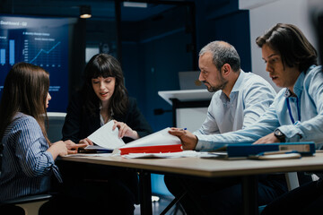 Business executives and assistants brainstorming investment risk evaluation in corporate boardroom