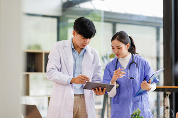 Obraz premium A Female nurse showing something on tablet to Male doctor both smiling in hospital 