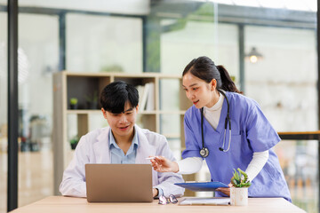 Fototapeta premium MIddle asian doctor and nurse sharing information on patient case in hospital hallway. 