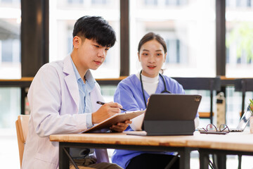 Obraz premium A Doctors and female nurse cooperating while working on laptop in the office. 