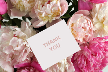 Bouquet of pink and white peonies framing a thank you card