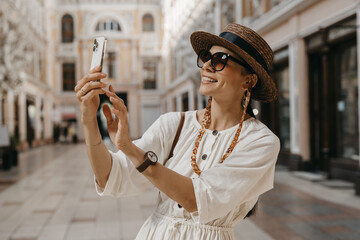 attractive woman walking in shopping street in Italy on vacation dressed in white summer fashion...
